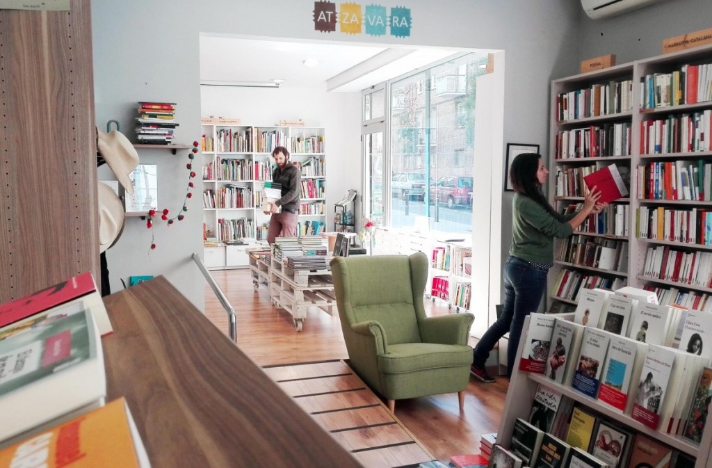 Libreria Atzavara por dentro. Acogedora, con muchos libros, y un sillón verde para sentarse a ojear. Ilustra lo que encontraran los que vayan a visitarla